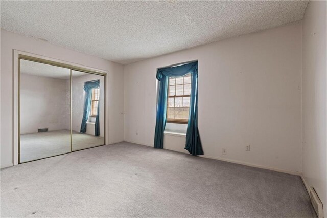 spare room featuring a textured ceiling and carpet flooring