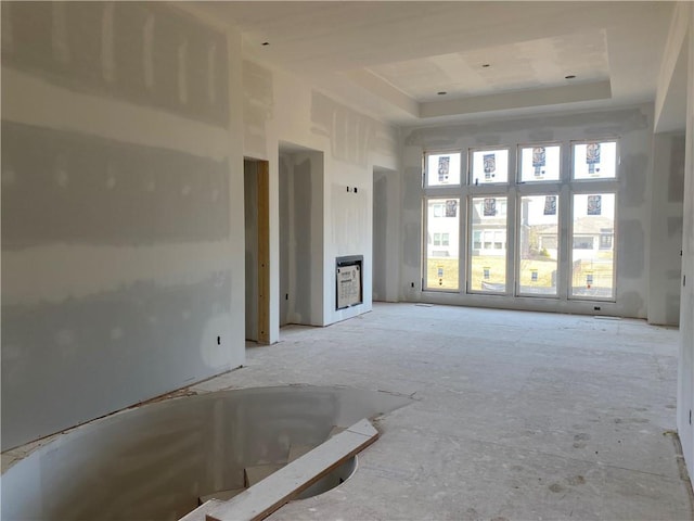 unfurnished living room with a tray ceiling and a high ceiling