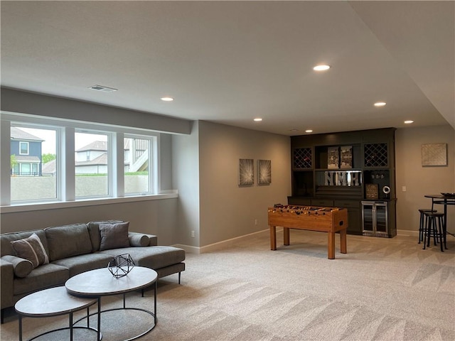 living room with recessed lighting, visible vents, light carpet, and baseboards