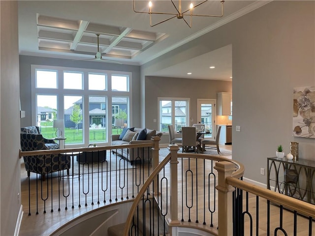 living room with crown molding, beamed ceiling, coffered ceiling, baseboards, and ceiling fan with notable chandelier