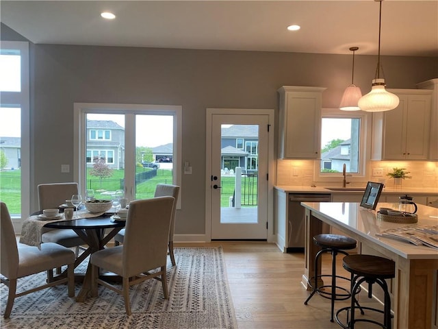 dining area with light wood-type flooring, a healthy amount of sunlight, and recessed lighting