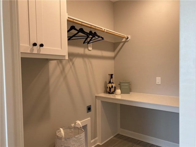 laundry room with dark wood-type flooring, hookup for an electric dryer, cabinet space, and baseboards