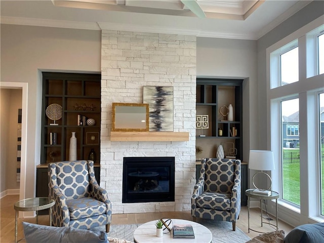 living room with crown molding, a stone fireplace, and wood finished floors