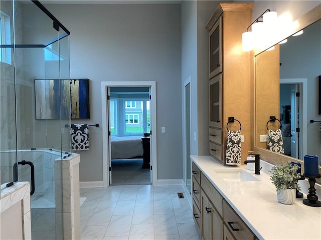 ensuite bathroom featuring vanity, ensuite bath, a stall shower, marble finish floor, and baseboards