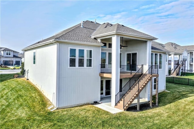 rear view of property with a lawn and ceiling fan