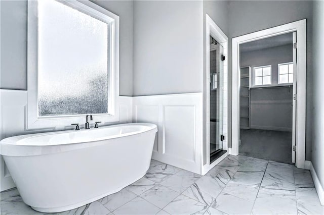 bathroom with plenty of natural light and a bath