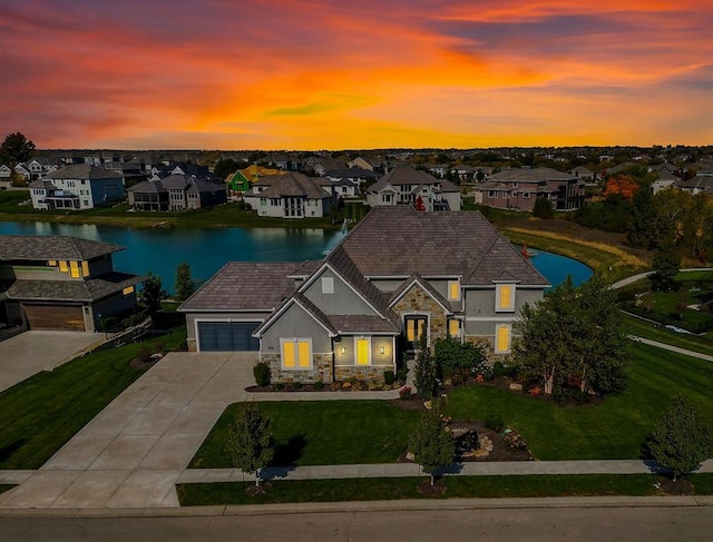 view of front of property with a residential view, a water view, a yard, and stucco siding