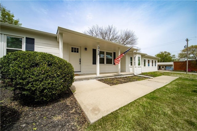 view of front of home featuring covered porch and a front lawn