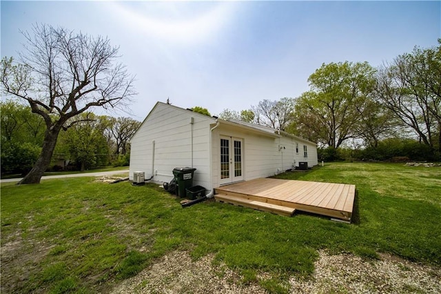 rear view of property featuring french doors, a yard, and a wooden deck