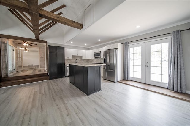 kitchen featuring french doors, decorative backsplash, a kitchen island, white cabinetry, and stainless steel appliances