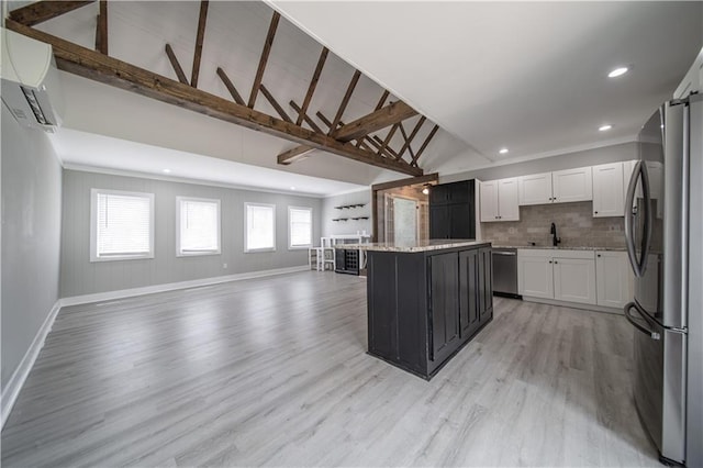 kitchen featuring an AC wall unit, vaulted ceiling with beams, a kitchen island, white cabinetry, and stainless steel appliances