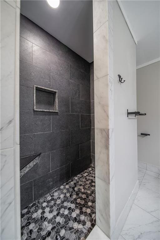 bathroom featuring a tile shower and crown molding