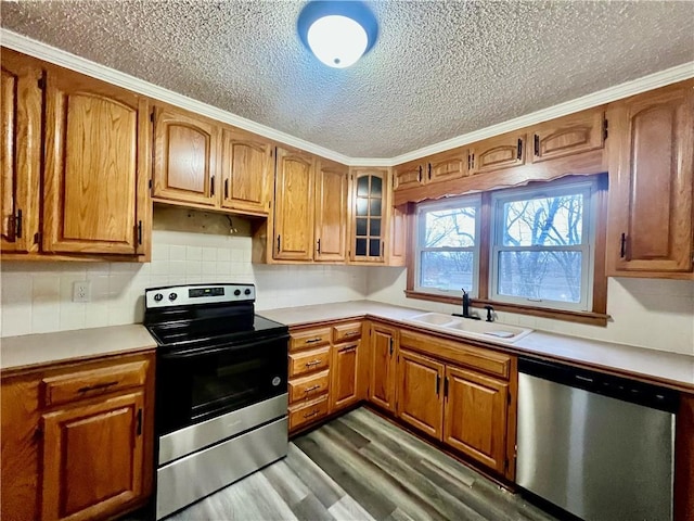 kitchen featuring appliances with stainless steel finishes, decorative backsplash, dark wood-type flooring, a textured ceiling, and sink