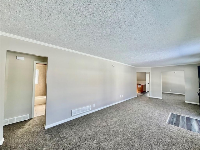 unfurnished room featuring a textured ceiling, ornamental molding, and dark colored carpet