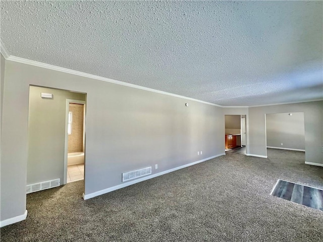 empty room with a textured ceiling, ornamental molding, and dark colored carpet