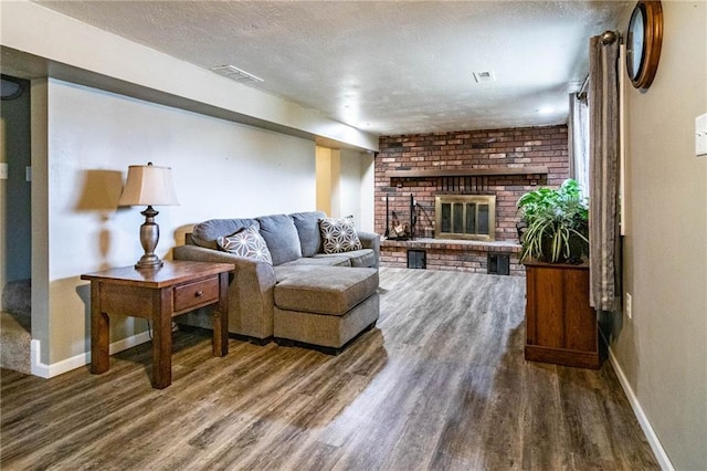 living room with a fireplace, dark hardwood / wood-style floors, and a textured ceiling