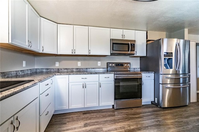 kitchen featuring white cabinets, dark wood-type flooring, and appliances with stainless steel finishes