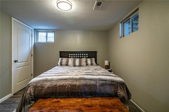 bedroom featuring a textured ceiling and dark wood-type flooring