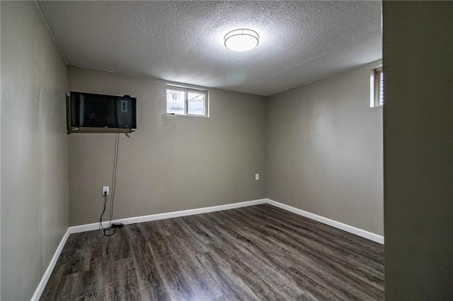 basement with a textured ceiling and dark hardwood / wood-style floors