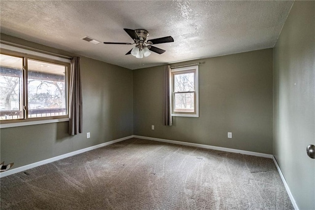 unfurnished room with a textured ceiling, carpet floors, and ceiling fan