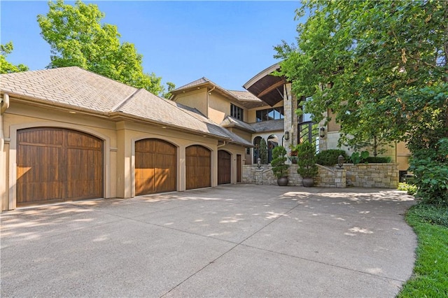 exterior space featuring a garage, stucco siding, and concrete driveway