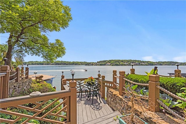 wooden terrace featuring a boat dock and a water view