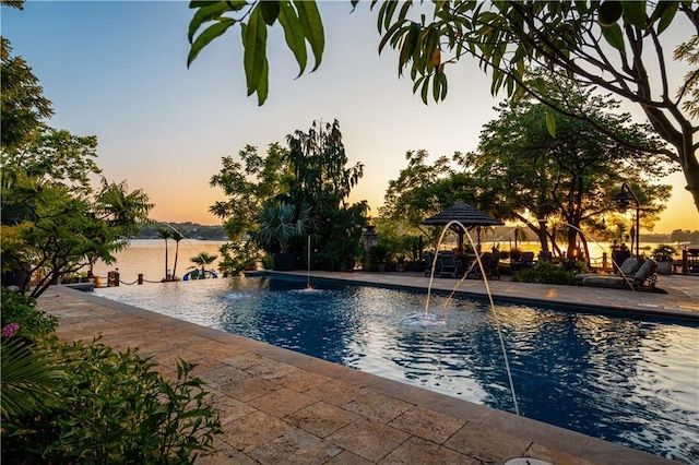 pool at dusk featuring an outdoor pool