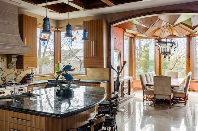 472 N Winnebago Dr, Lake Winnebago, MO 64034 - kitchen with brown cabinets, plenty of natural light, custom exhaust hood, and tasteful backsplash