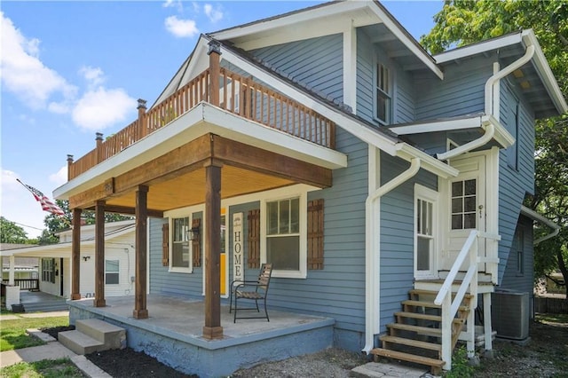 back of house with central air condition unit, a balcony, and covered porch