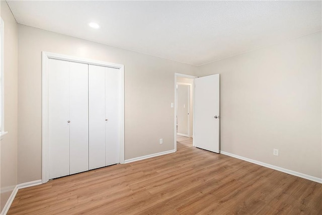 unfurnished bedroom featuring light hardwood / wood-style floors and a closet