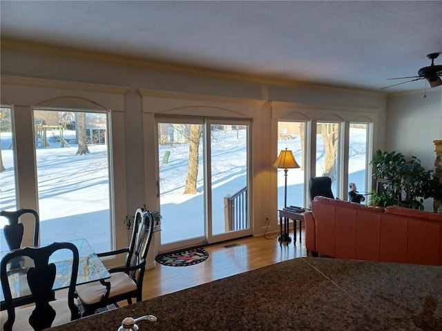 living area featuring light wood-type flooring, ceiling fan, crown molding, and a wealth of natural light