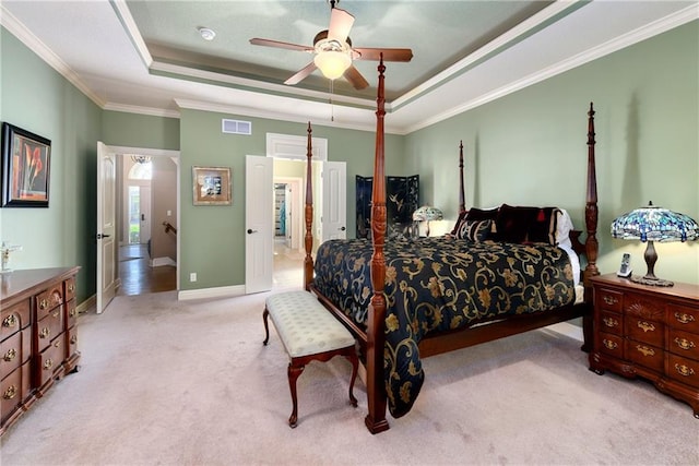 bedroom featuring crown molding, a raised ceiling, visible vents, light carpet, and baseboards