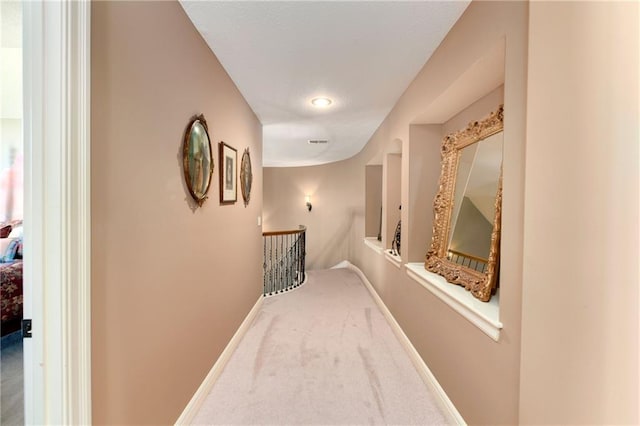 hall with carpet, an upstairs landing, and baseboards