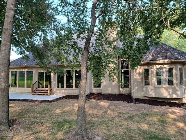 back of house featuring a shingled roof and a patio