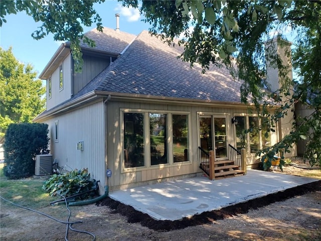 rear view of property featuring entry steps, a patio, roof with shingles, and cooling unit