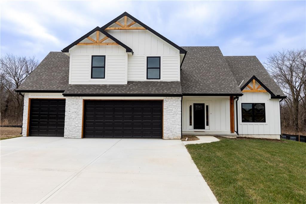 modern inspired farmhouse featuring a garage and a front yard