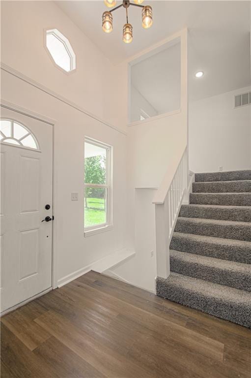 foyer with high vaulted ceiling, a chandelier, and dark hardwood / wood-style floors