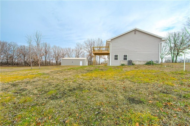 view of side of property featuring central air condition unit, a yard, an outdoor structure, and a deck