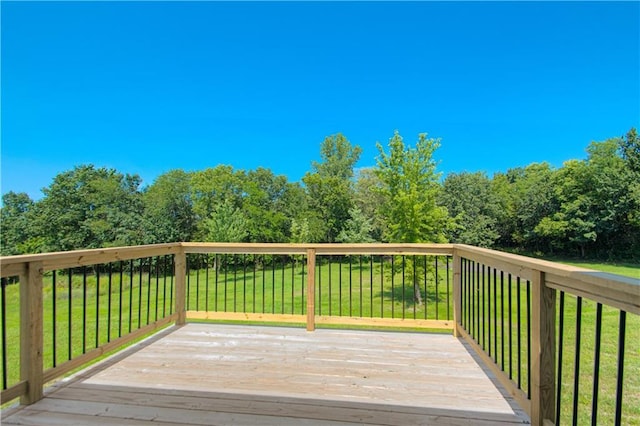 wooden deck featuring a lawn