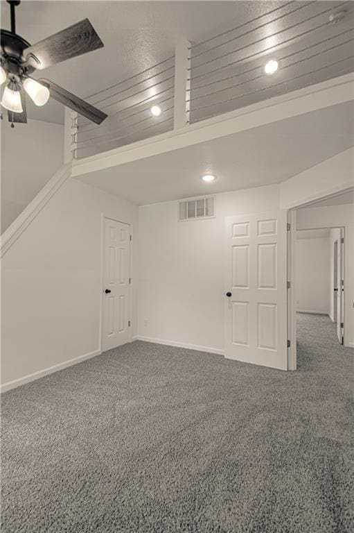 basement featuring carpet flooring and ceiling fan