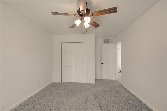 unfurnished bedroom featuring carpet floors, a closet, and ceiling fan