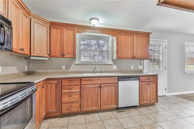 kitchen with appliances with stainless steel finishes, backsplash, a healthy amount of sunlight, and sink