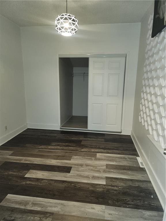 unfurnished bedroom featuring dark hardwood / wood-style floors and a closet