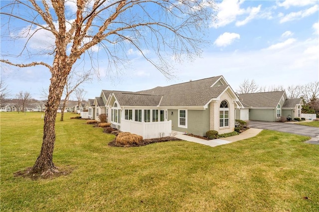 single story home with a sunroom and a front yard