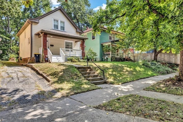 view of front of home with covered porch and a front yard