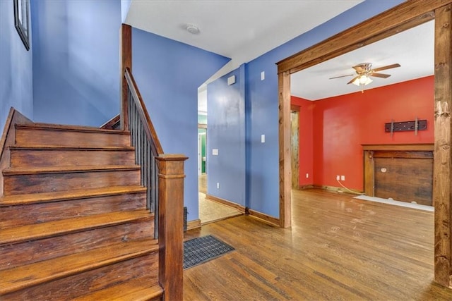 stairs featuring hardwood / wood-style floors and ceiling fan