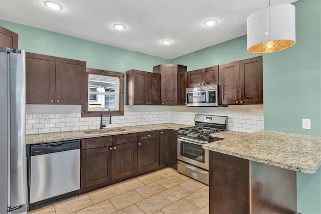 kitchen with hanging light fixtures, tasteful backsplash, sink, and stainless steel appliances