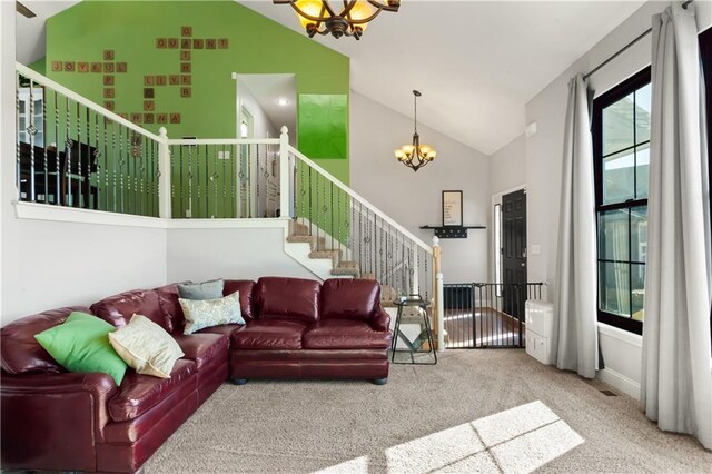 carpeted living room with a notable chandelier and high vaulted ceiling