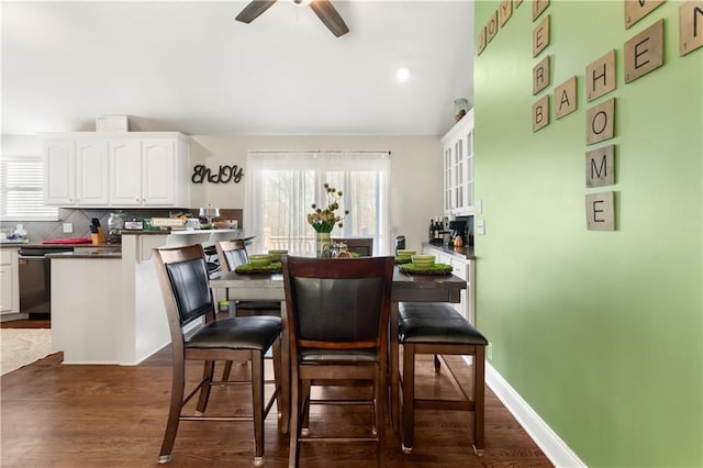 dining space with dark wood-type flooring and ceiling fan