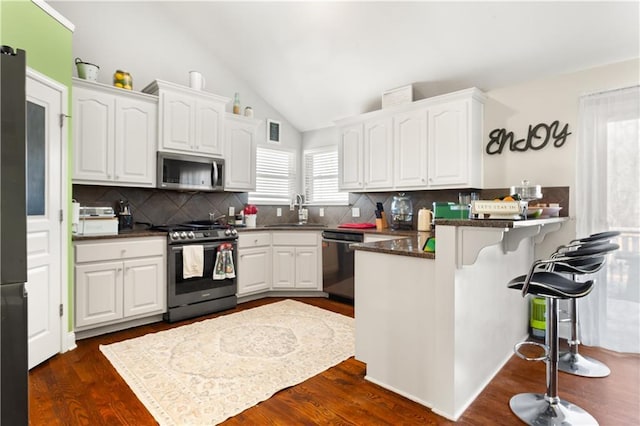 kitchen featuring appliances with stainless steel finishes, sink, white cabinets, and kitchen peninsula